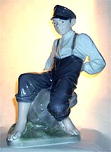 Royal Copenhagen Figurine - Boy On Stone